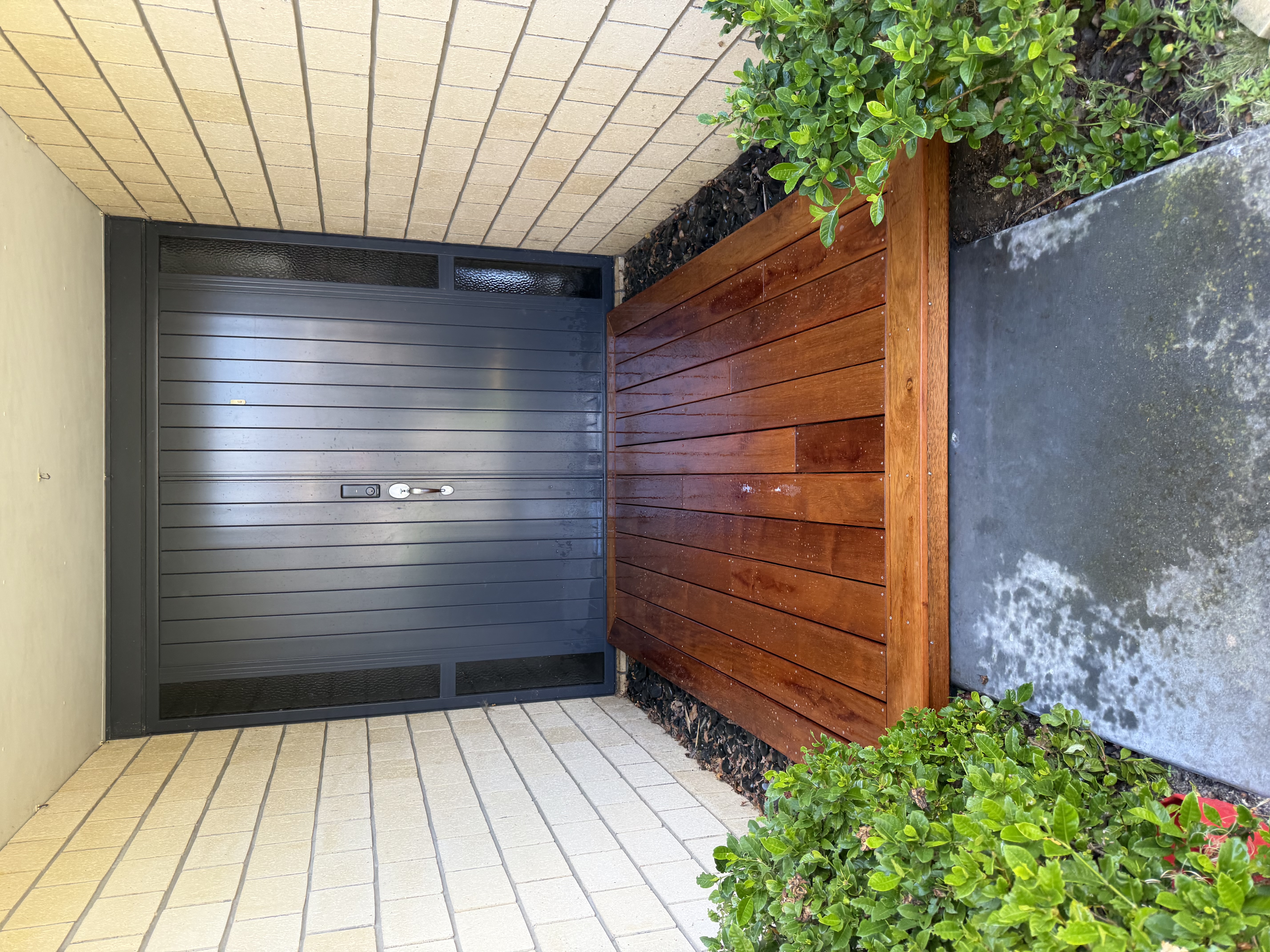 Hardwood entrance deck platform at front door with garden beds — Element Landscaping Waikato